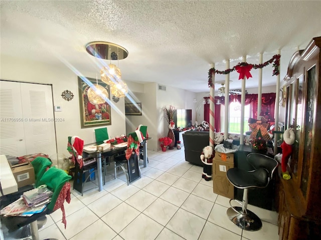 tiled dining area with a textured ceiling