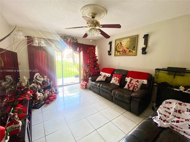 living room featuring ceiling fan, light tile patterned floors, and a textured ceiling