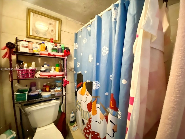 bathroom with a shower with shower curtain and toilet