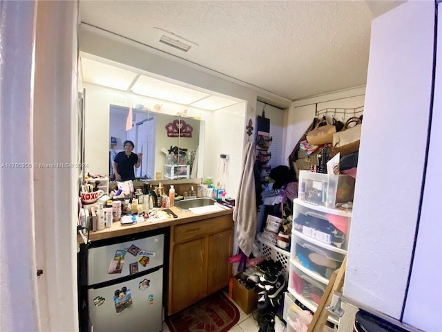 bathroom with tile patterned flooring, vanity, and a textured ceiling