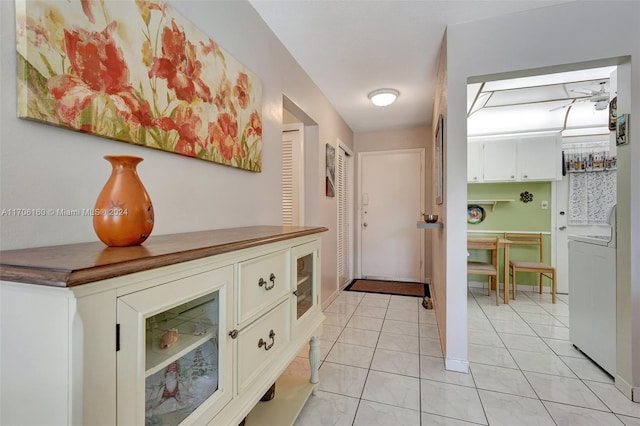 hallway with light tile patterned flooring and washer / dryer