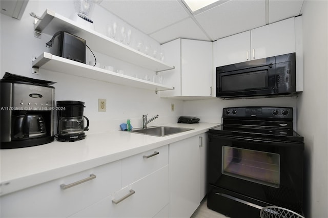 kitchen featuring sink, white cabinetry, a paneled ceiling, and black appliances