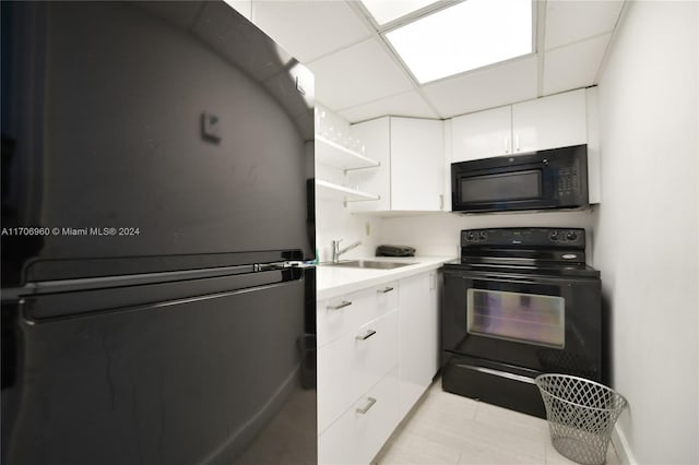 kitchen featuring black appliances, a drop ceiling, white cabinetry, and sink