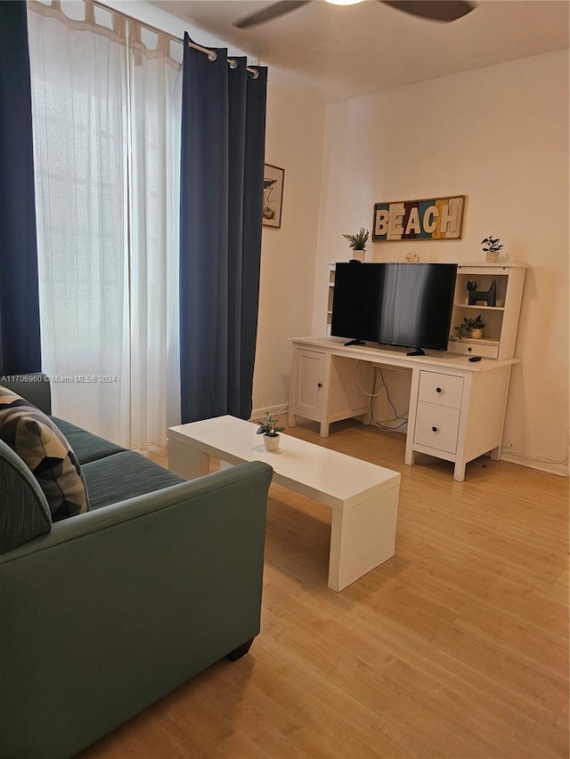 living room with light wood-type flooring and ceiling fan