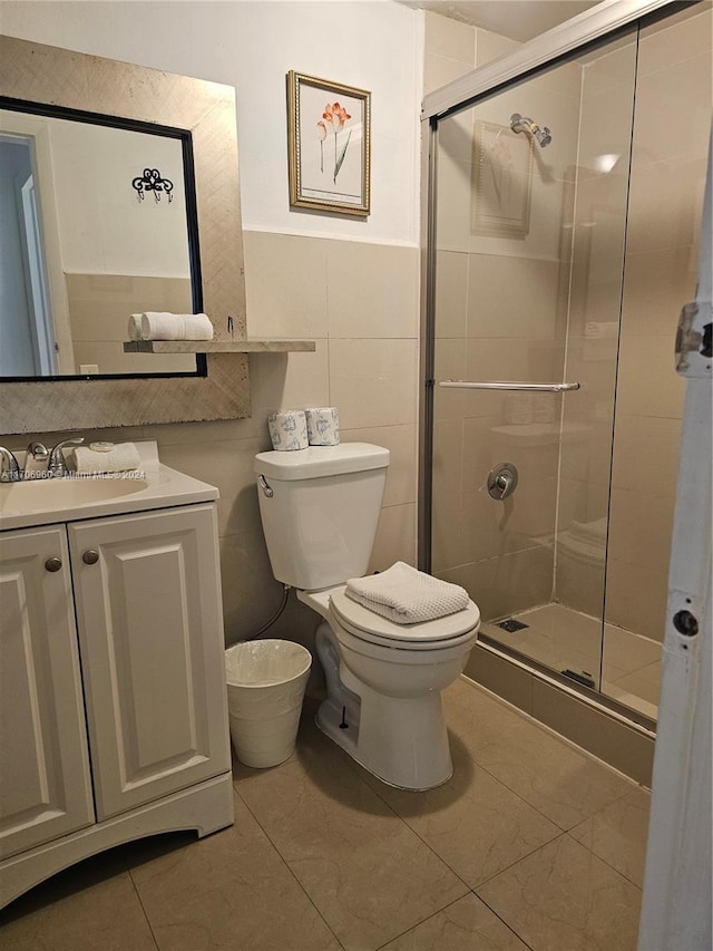 bathroom featuring tile patterned floors, toilet, vanity, and walk in shower