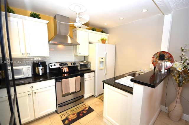 kitchen with white cabinets, white appliances, and wall chimney range hood