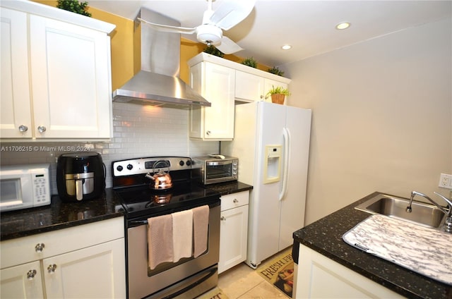 kitchen with white appliances, white cabinets, sink, wall chimney exhaust hood, and light tile patterned floors