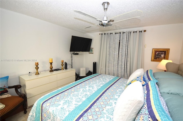 bedroom with ceiling fan and a textured ceiling