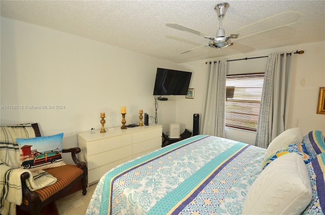 bedroom with carpet flooring, ceiling fan, and a textured ceiling