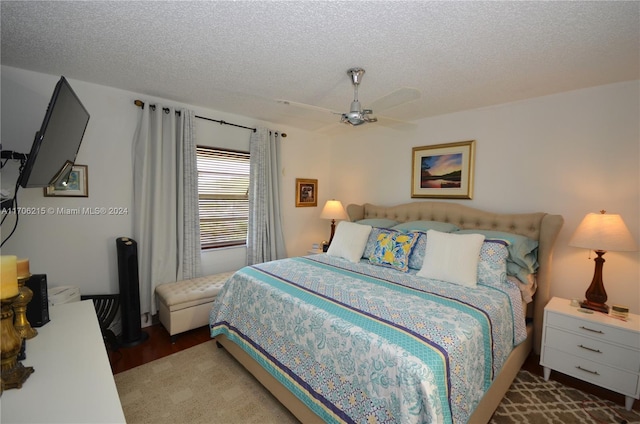 bedroom featuring ceiling fan, a textured ceiling, and hardwood / wood-style flooring