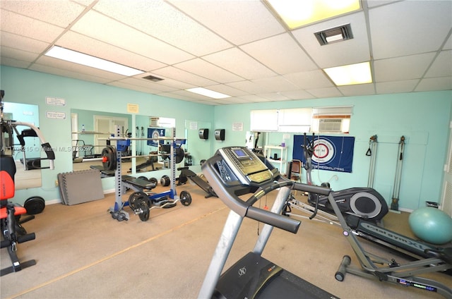 gym featuring a paneled ceiling and light carpet