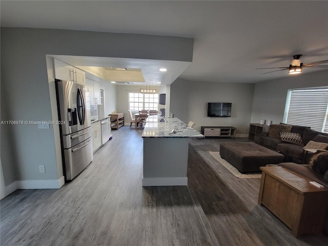 kitchen with hardwood / wood-style floors, ceiling fan, light stone counters, white cabinetry, and stainless steel appliances