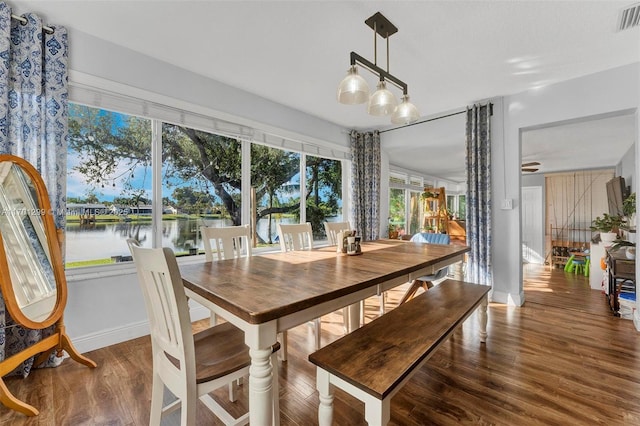 dining area featuring hardwood / wood-style flooring and a water view