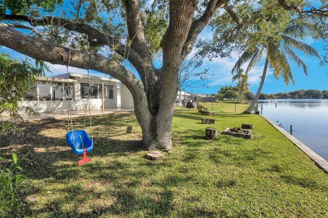 view of yard with a sunroom and a water view