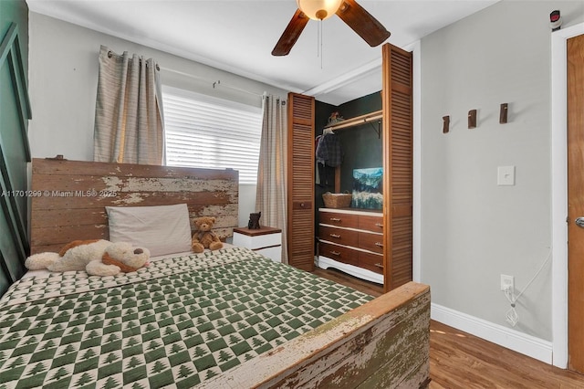 bedroom with dark hardwood / wood-style flooring, ceiling fan, and a closet