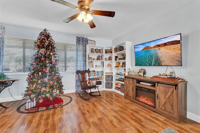 sitting room with light hardwood / wood-style flooring, ceiling fan, and a textured ceiling