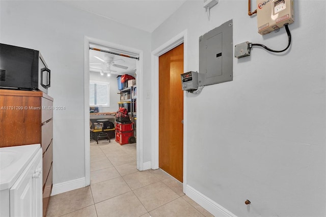 hall featuring light tile patterned floors and electric panel