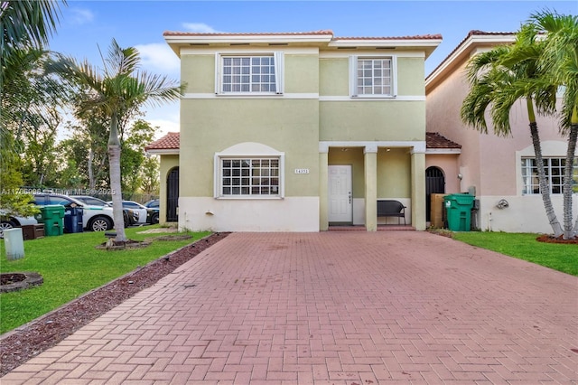 mediterranean / spanish house with a front lawn