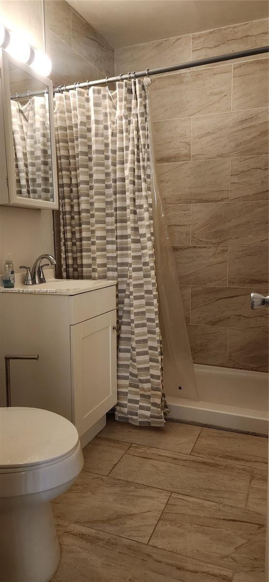 bathroom with vanity, toilet, and curtained shower