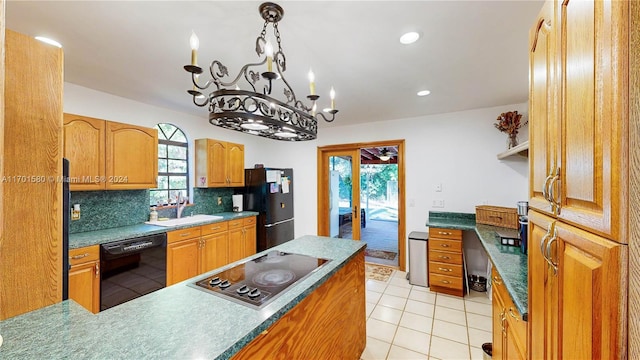 kitchen featuring sink, tasteful backsplash, a healthy amount of sunlight, and black appliances