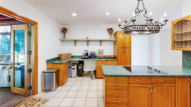 kitchen with black electric stovetop, light tile patterned flooring, and an inviting chandelier