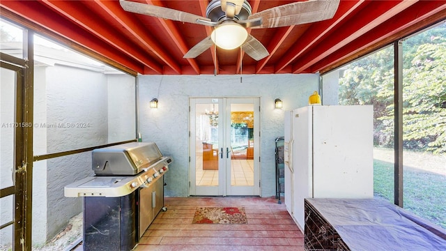 sunroom / solarium featuring ceiling fan and french doors