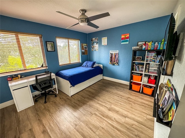 bedroom featuring ceiling fan, a textured ceiling, and light hardwood / wood-style flooring