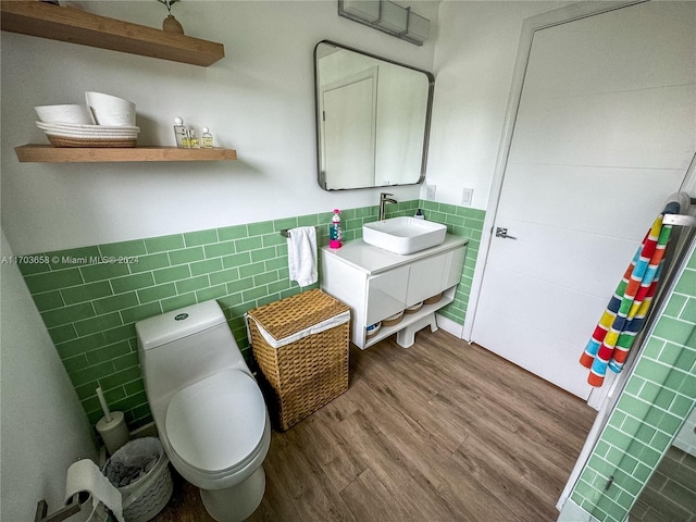 bathroom featuring hardwood / wood-style floors, vanity, toilet, and tile walls