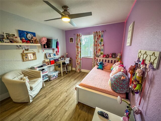 bedroom featuring hardwood / wood-style flooring, ceiling fan, and a textured ceiling