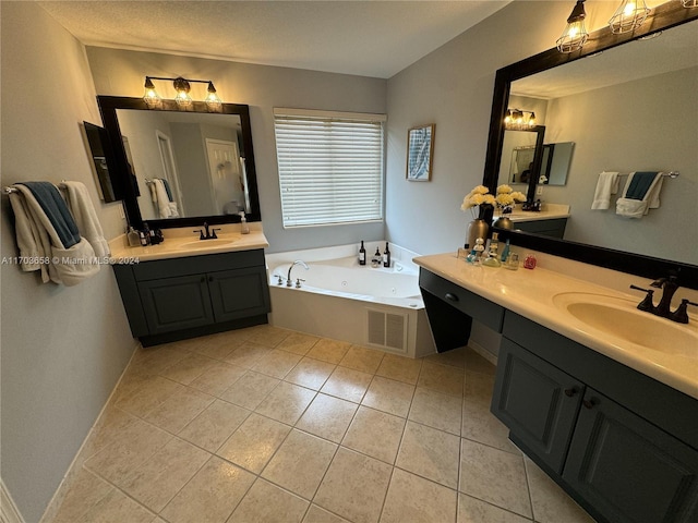 bathroom featuring tile patterned flooring, vanity, a tub, and a textured ceiling