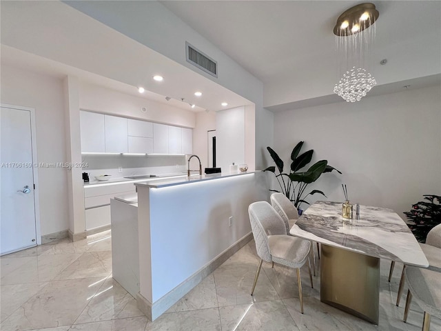 1755 E Hallandale Beach Blvd Unit 405E, Hallandale Beach, FL 33009 - kitchen with light marble finish floors, white cabinets, modern cabinets, recessed lighting, and light countertops