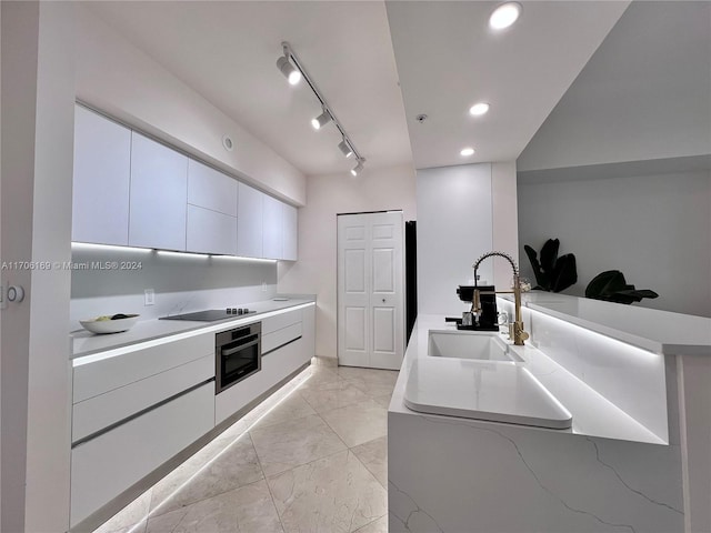 1755 E Hallandale Beach Blvd Unit 405E, Hallandale Beach, FL 33009 - kitchen featuring oven, light marble finish floors, modern cabinets, white cabinets, and light countertops