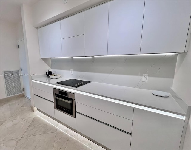 kitchen with black electric stovetop and stainless steel oven