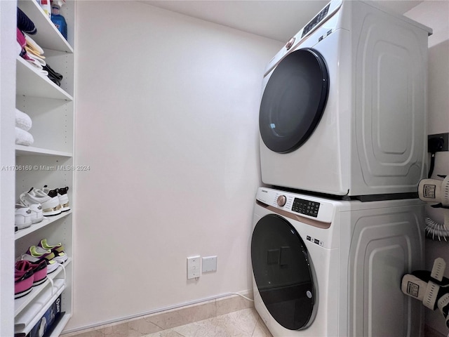 laundry room with stacked washer / dryer and light tile patterned flooring