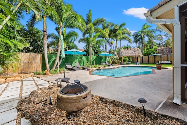 view of pool featuring a gazebo, a fire pit, and a patio area