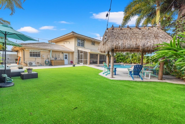 rear view of house with an outdoor hangout area, a patio area, and a lawn