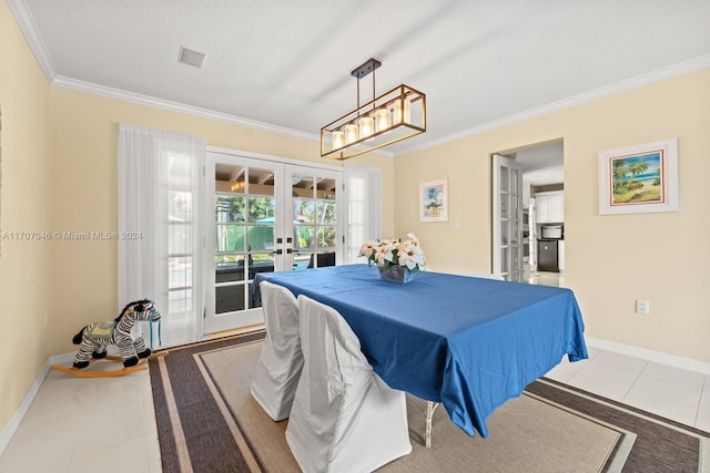 dining area featuring tile patterned floors, ornamental molding, a textured ceiling, and french doors