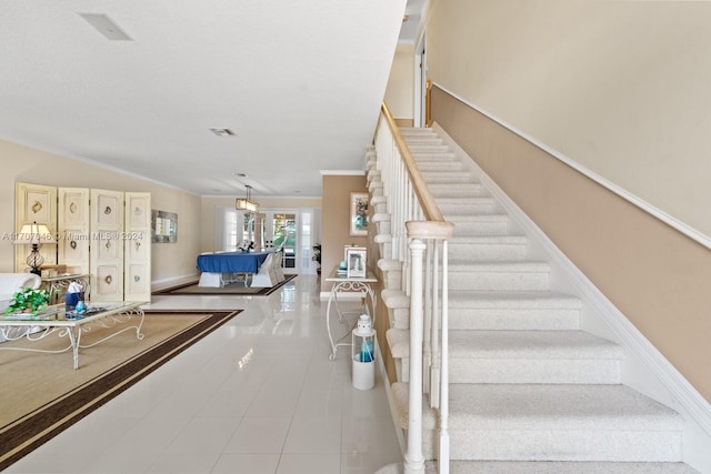 staircase featuring french doors, tile patterned floors, and ornamental molding