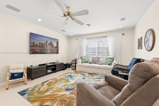 tiled living room with ceiling fan and a textured ceiling