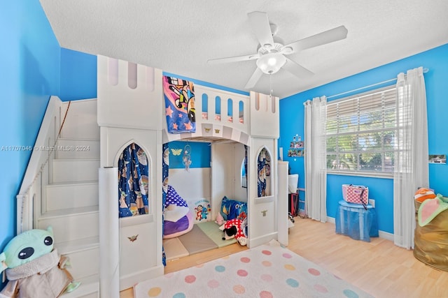 bedroom featuring ceiling fan, a textured ceiling, and light wood-type flooring