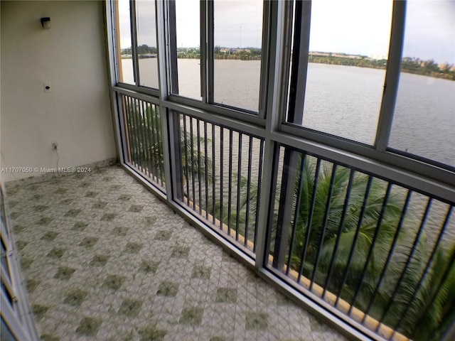 unfurnished sunroom with plenty of natural light and a water view