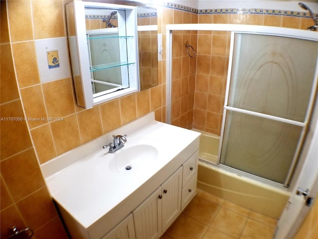 bathroom with shower / bath combination with glass door, vanity, tile patterned floors, and tile walls