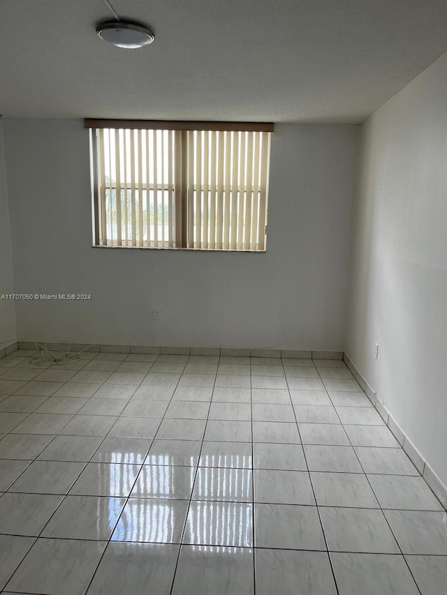 tiled spare room with plenty of natural light