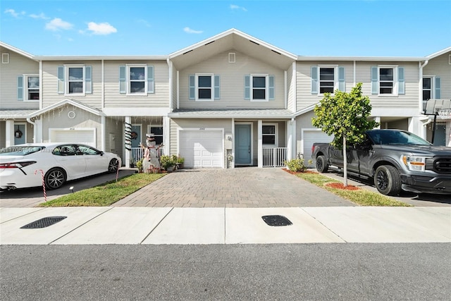 townhome / multi-family property with a porch and a garage