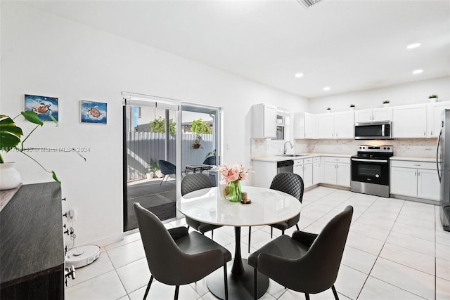 dining room featuring sink and light tile patterned floors