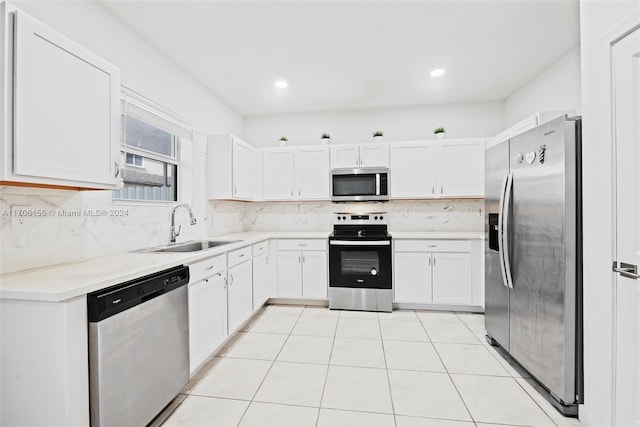 kitchen with decorative backsplash, stainless steel appliances, white cabinetry, and sink