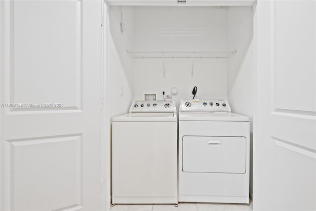 clothes washing area featuring light tile patterned flooring and washing machine and clothes dryer