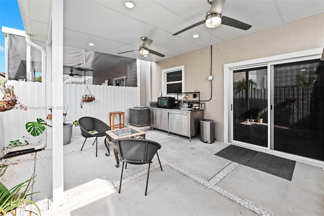 view of patio featuring a fire pit, cooling unit, and sink