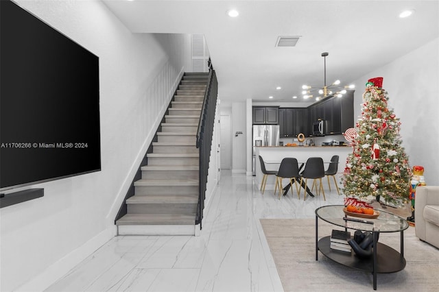 staircase with an inviting chandelier