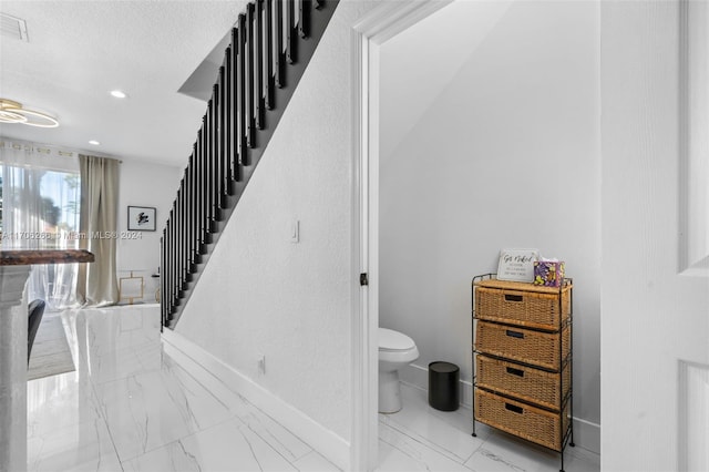 stairs with a textured ceiling